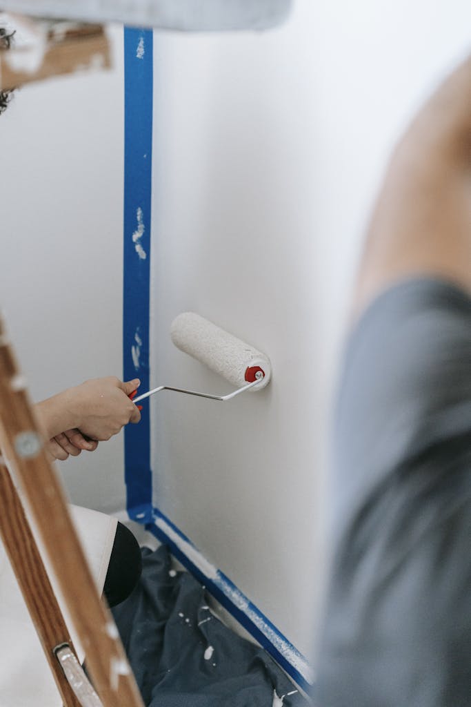 People Painting A Wall